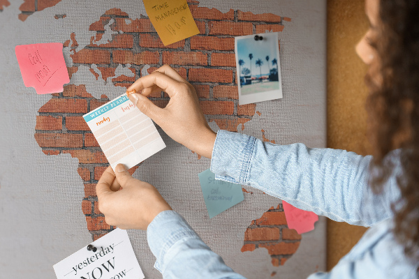 Kurkbord wereldkaart tegen een bakstenen muur