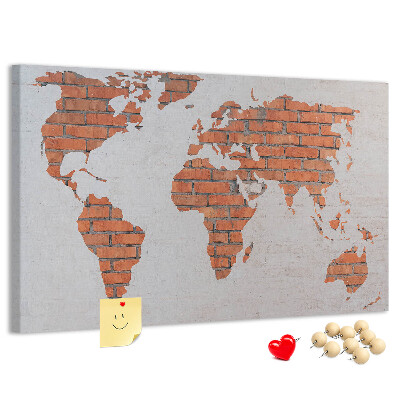 Kurkbord wereldkaart tegen een bakstenen muur