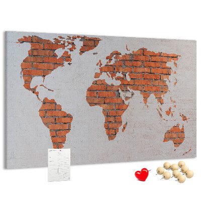 Kurkbord wereldkaart tegen een bakstenen muur