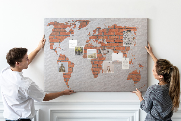 Kurkbord wereldkaart tegen een bakstenen muur