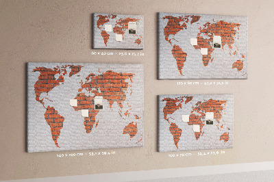 Kurkbord wereldkaart tegen een bakstenen muur