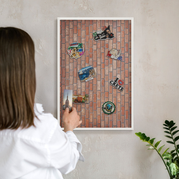 Magnetisch bord van metaal in een witte lijst Bakstenen muur