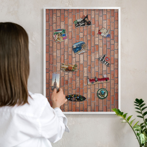Magnetisch bord van metaal in een witte lijst Bakstenen muur