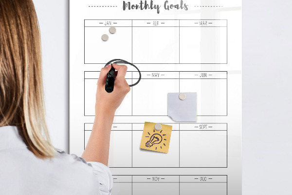 Decoratief glazen wandbord beschrijfbaar en magnetisch Maandelijkse doelen met de mogelijkheid om ze te personaliseren.
