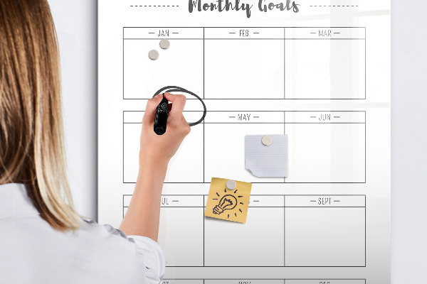 Decoratief glazen wandbord beschrijfbaar en magnetisch Maandelijkse doelen met de mogelijkheid om ze te personaliseren.