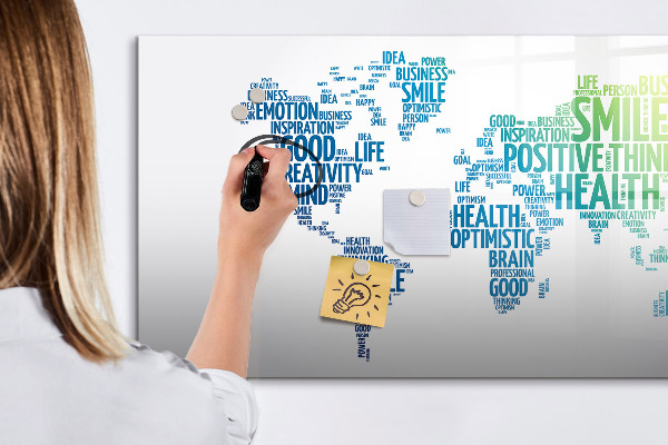 Decoratief glazen wandbord beschrijfbaar en magnetisch Een wereld vol ideeën en positiviteit.