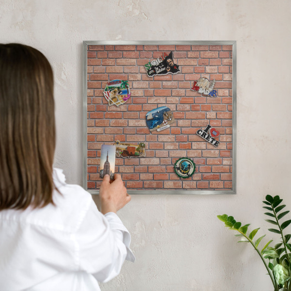Decoratief metalen magneetbord in een zilveren lijst Bakstenen muur