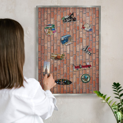 Decoratief metalen magneetbord in een zilveren lijst Bakstenen muur