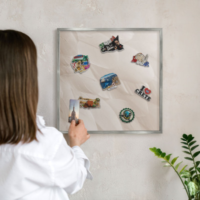 Decoratief metalen magneetbord in een zilveren lijst Crèmekleurige veren
